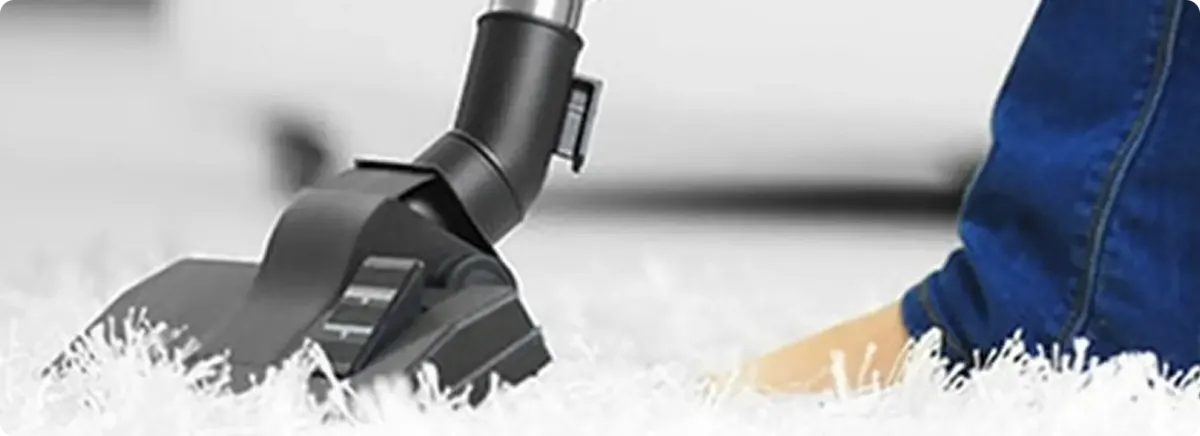 Close-up of a professional vacuuming a white carpet in Calabash.